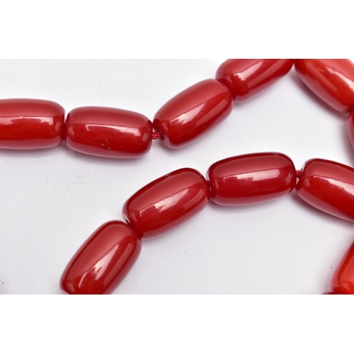 9 - A CHERRY AMBER BAKELITE BEAD NECKLACE, designed with a single row of thirty-five barrel shape beads,... 