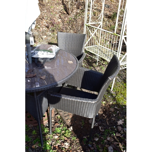 903 - A FAUX BLACK RATTAN GARDEN TABLE, with a glass insert, diameter 101cm x height 76cm, and four armcha... 