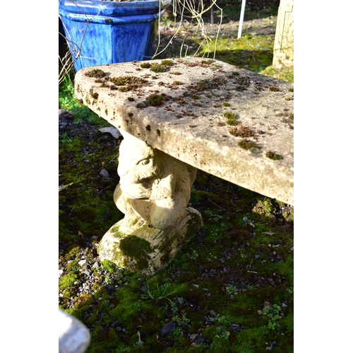 914 - A WEATHERED COMPOSITE CURVED BENCH, on a pair of squirrel shaped bases, length 115cm (condition:-no ... 