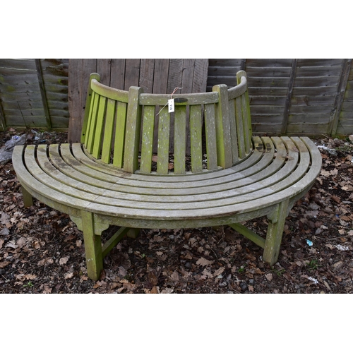 918 - A WEATHERED TEAK HALF CIRCLE TREE BENCH, labelled  PTC Imports London, length 200cm x inner width 86... 