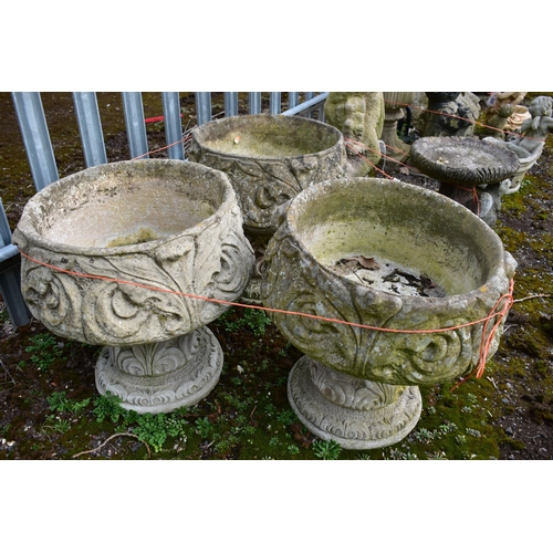 927 - A SET OF THREE WEATHERED COMPOSITE PLANTERS, on separate bases, diameter 45cm x height 45cm (conditi... 