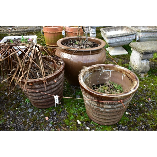 933 - A BROWN GLAZED CIRCULAR PLANT PLANTER, of a ribbed tapered design, diameter 47cm x height 40cm, and ... 