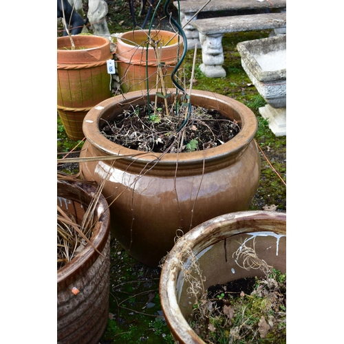 933 - A BROWN GLAZED CIRCULAR PLANT PLANTER, of a ribbed tapered design, diameter 47cm x height 40cm, and ... 