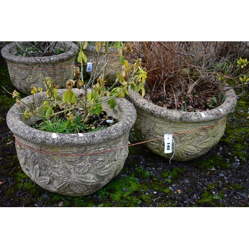 940 - A PAIR OF WEATHERED COMPOSITE CIRCULAR PLANTERS, with a floral design, diameter 53cm x height 36cm (... 