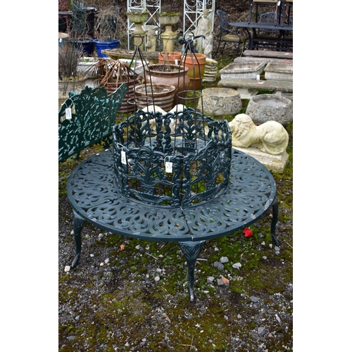 942 - A CAST ALUMINIUM ROUND TREE BENCH, decorated with still life flowers to the backrest, scrolls to the... 