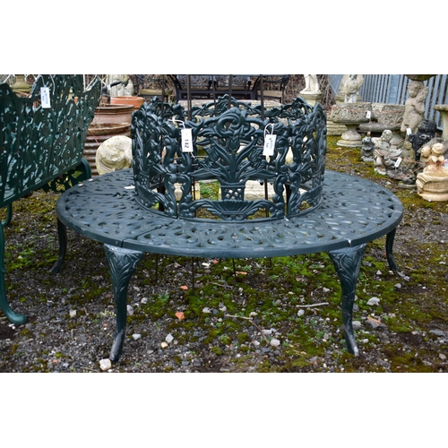 942 - A CAST ALUMINIUM ROUND TREE BENCH, decorated with still life flowers to the backrest, scrolls to the... 