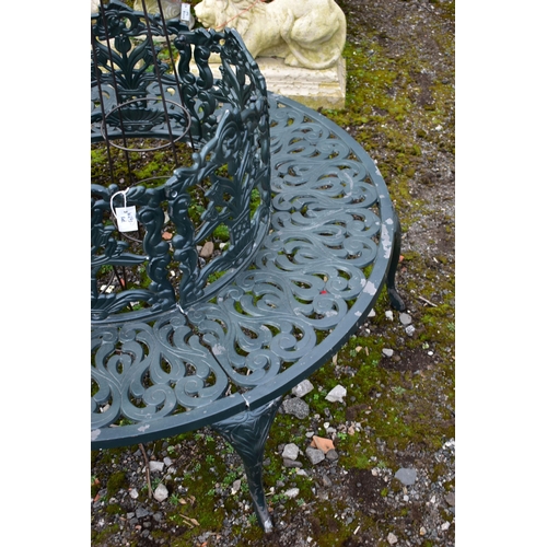 942 - A CAST ALUMINIUM ROUND TREE BENCH, decorated with still life flowers to the backrest, scrolls to the... 