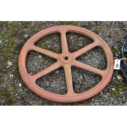 952 - A  CAST IRON MACHINE PULL WHEEL, diameter 63cm, along with a pair of  black painted kart wheels, dia... 