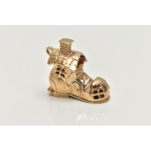 16 - A 9CT GOLD CHARM, yellow gold charm of a boot house, fitted with a hinged sole, opens to reveal chil... 