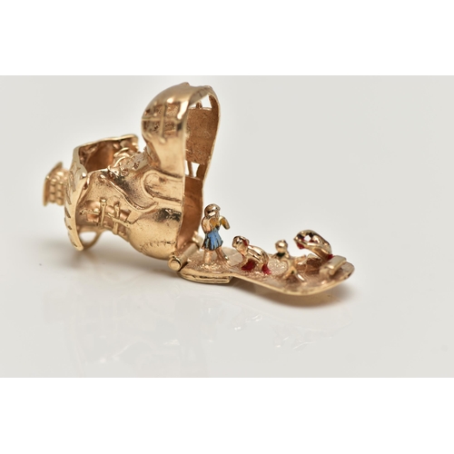 16 - A 9CT GOLD CHARM, yellow gold charm of a boot house, fitted with a hinged sole, opens to reveal chil... 