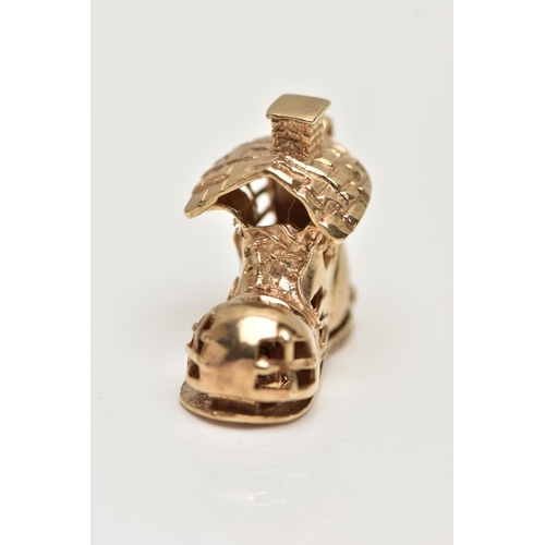 16 - A 9CT GOLD CHARM, yellow gold charm of a boot house, fitted with a hinged sole, opens to reveal chil... 