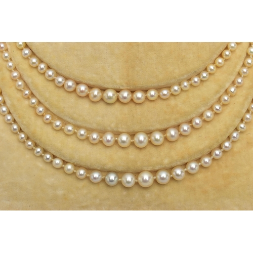 4 - A CULTURED PEARL NECKLACE WITH EMERALD AND DIAMOND CLASP, designed as three graduating rows of cultu... 