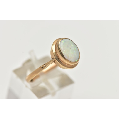 48 - A 9CT GOLD OPAL RING, designed with an oval opal cabochon, collet set to the yellow gold rim, pinche... 