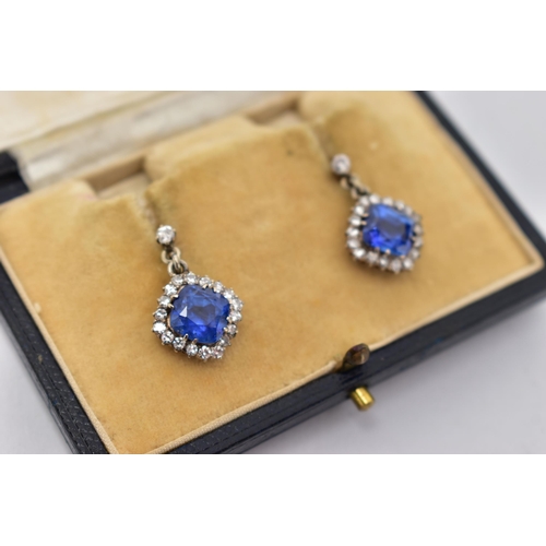 5 - A PAIR OF EARLY 20TH CENTURY SAPPHIRE AND DIAMOND EARRINGS, each earring set with a cushion cut sapp... 