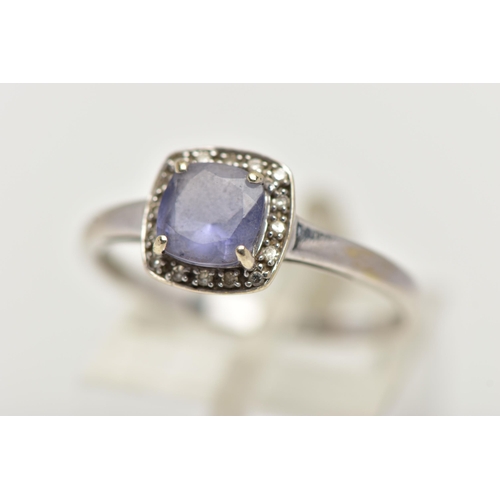 56 - A WHITE METAL IOLITE AND DIAMOND CLUSTER RING, designed with a square cut iolite within a surround o... 