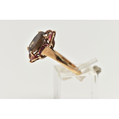 57 - A 9CT GOLD SMOKY QUARTZ RING, designed with a claw set, oval cut smoky quartz, within an openwork su... 