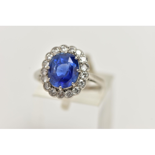 6 - A SAPPHIRE AND DIAMOND CLUSTER RING, set with a mixed cut, cushion sapphire, measuring approximately... 