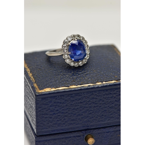 6 - A SAPPHIRE AND DIAMOND CLUSTER RING, set with a mixed cut, cushion sapphire, measuring approximately... 