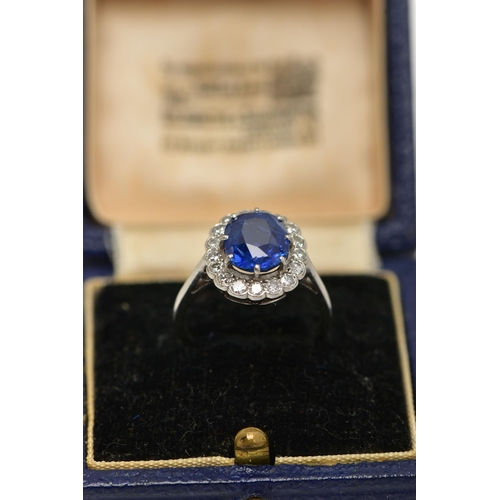 6 - A SAPPHIRE AND DIAMOND CLUSTER RING, set with a mixed cut, cushion sapphire, measuring approximately... 