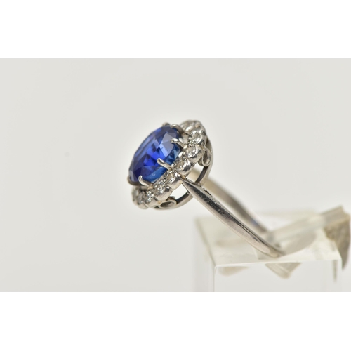 6 - A SAPPHIRE AND DIAMOND CLUSTER RING, set with a mixed cut, cushion sapphire, measuring approximately... 