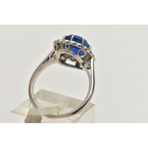 6 - A SAPPHIRE AND DIAMOND CLUSTER RING, set with a mixed cut, cushion sapphire, measuring approximately... 