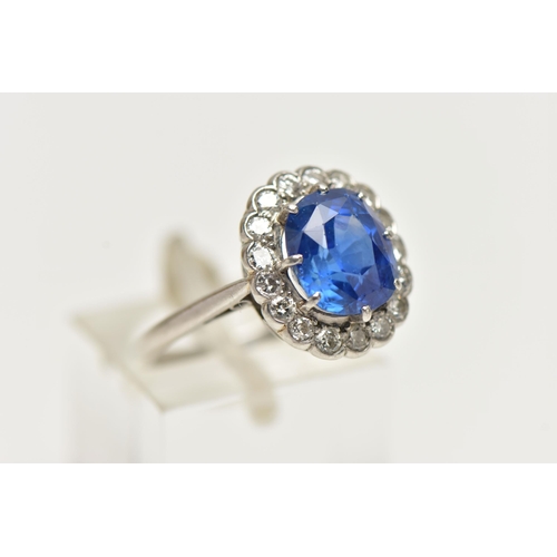 6 - A SAPPHIRE AND DIAMOND CLUSTER RING, set with a mixed cut, cushion sapphire, measuring approximately... 