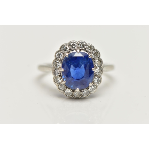 6 - A SAPPHIRE AND DIAMOND CLUSTER RING, set with a mixed cut, cushion sapphire, measuring approximately... 