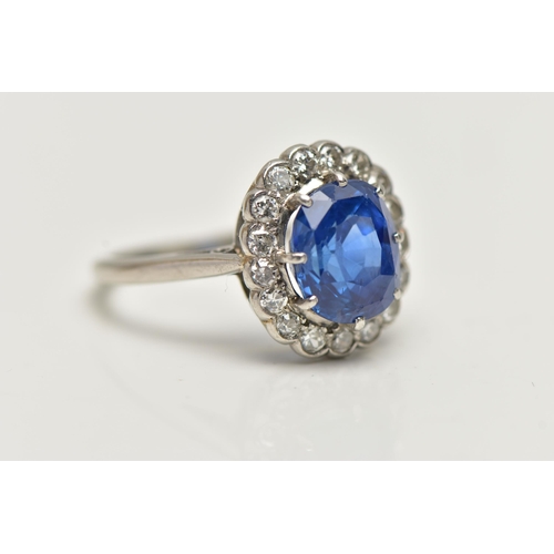 6 - A SAPPHIRE AND DIAMOND CLUSTER RING, set with a mixed cut, cushion sapphire, measuring approximately... 