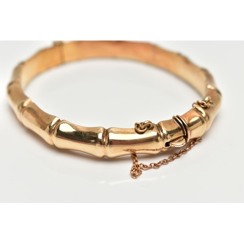 7 - A 9CT GOLD 'SMITH & PEPPER' BANGLE, a yellow gold bamboo style hollow hinged bangle, fitted with an ... 