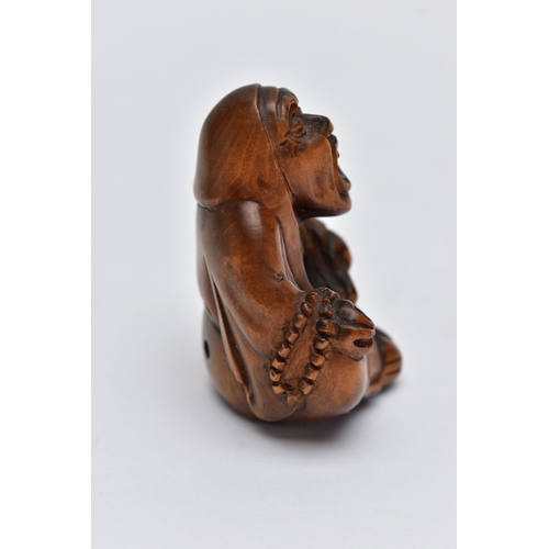 75 - A CARVED NETSUKE FIGURE, in the form of a seated robed elder, drill holes to the back, approximate h... 