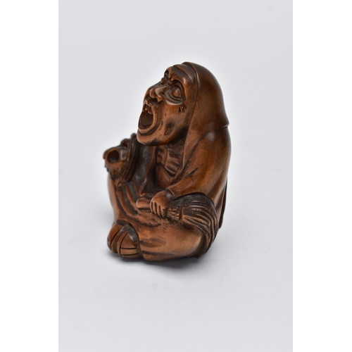 75 - A CARVED NETSUKE FIGURE, in the form of a seated robed elder, drill holes to the back, approximate h... 