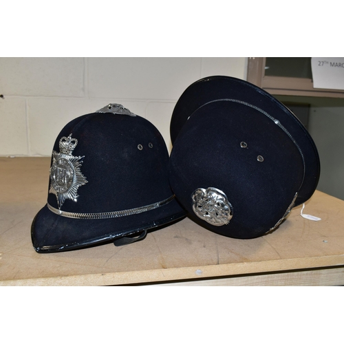 492 - TWO POLICE OFFICERS HELMETS, with West Midlands Police badges and roses to top (one rose dented) (2)