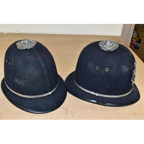 492 - TWO POLICE OFFICERS HELMETS, with West Midlands Police badges and roses to top (one rose dented) (2)