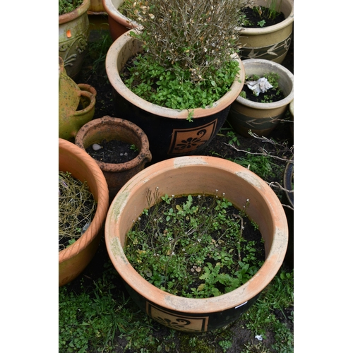 1007 - SIXTEEN PLANT POTS including a pair of green glazed pots with two foliate panels to each, diameter 3... 