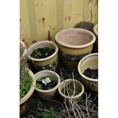 1007 - SIXTEEN PLANT POTS including a pair of green glazed pots with two foliate panels to each, diameter 3... 