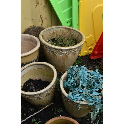 1007 - SIXTEEN PLANT POTS including a pair of green glazed pots with two foliate panels to each, diameter 3... 