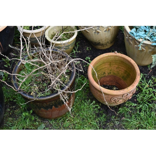 1007 - SIXTEEN PLANT POTS including a pair of green glazed pots with two foliate panels to each, diameter 3... 