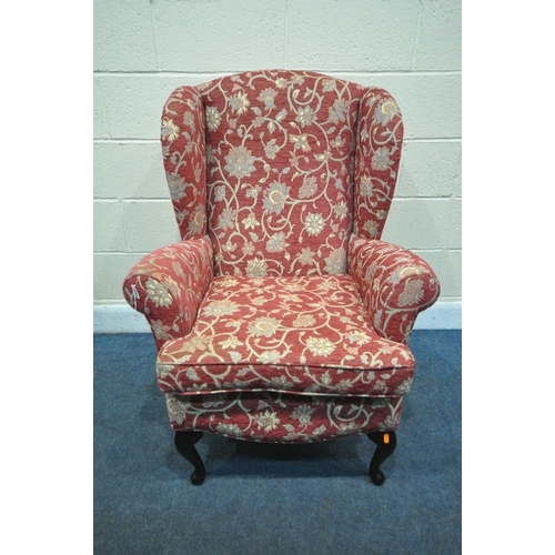 1299 - A RED FLORAL PATTERN WING BACK ARMCHAIR, on ebonised cabriole legs (condition:-slightly dirty armres... 