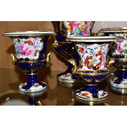 350 - SEVEN VICTORIAN PORCELAIN TWIN HANDLED URNS, hand painted with panels of flowers on a fish scale blu... 