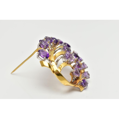 20 - A YELLOW METAL AMETHYST 'LOTOS' SPRAY BROOCH, foliage spray design set with eighteen oval cut amethy... 