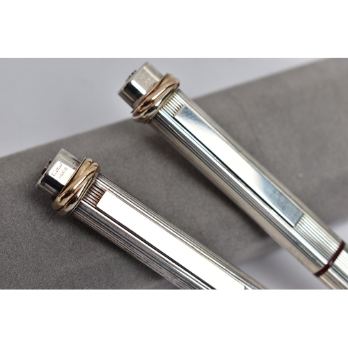 40 - A PAIR OF 'CARTIER' LES DE MUST VENDOME TRINITY PENS, a fountain pen, bugandy resin, silver tone cas... 