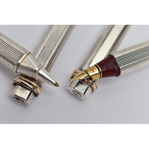 40 - A PAIR OF 'CARTIER' LES DE MUST VENDOME TRINITY PENS, a fountain pen, bugandy resin, silver tone cas... 