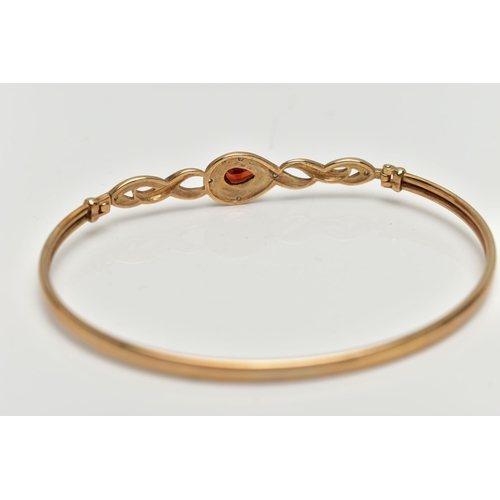 42 - A 9CT GOLD GARNET AND DIAMOND SET BANGLE, thin band, locking hinged clasp set with a pear cut garnet... 