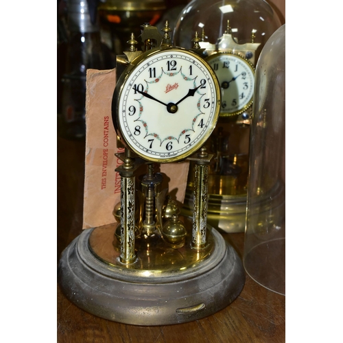 430 - TWO BRASS ANNIVERSARY CLOCKS, comprising one with a glass dome mechanism marked 72632, with key (gla... 