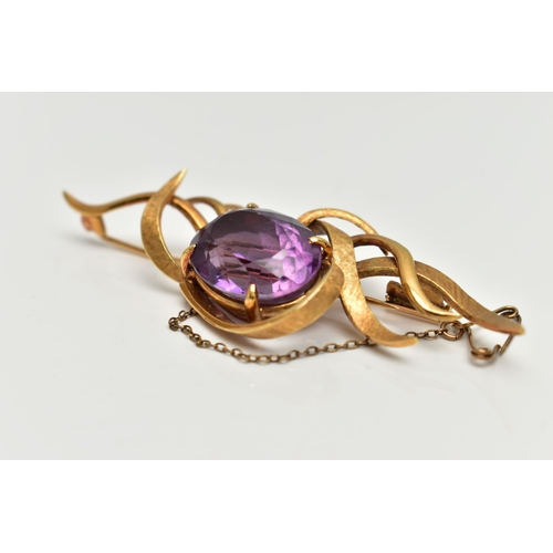 1 - A YELLOW METAL AMETHYST SPRAY BROOCH, designed with a four claw set, oval cut amethyst, within a spr... 