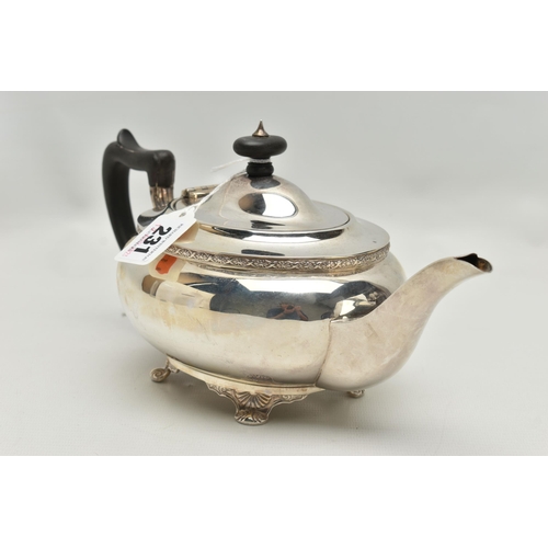 231 - A GEORGE V SILVER TEA POT OF SHAPED OVAL FORM, ebonised fitments, foliate cast rim and feet, makers ... 