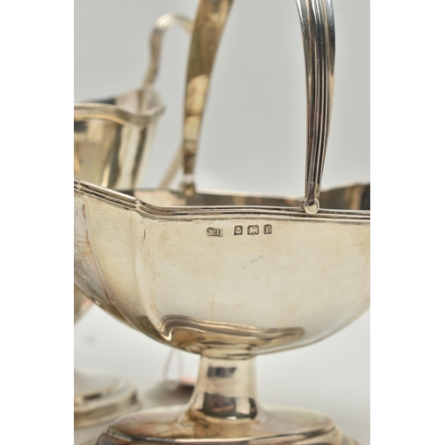 232 - AN EDWARDIAN MATCHED MILK JUG AND SWING HANDLED SUGAR BASKET OF PANELLED OVAL FORM, reeded rims, sho... 