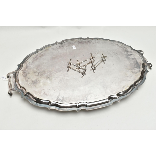 253 - AN EPNS TWIN HANDLED TRAY OF WAVY OVAL FORM AND THREE PLATED KNIFE RESTS, the tray with scrolled ove... 