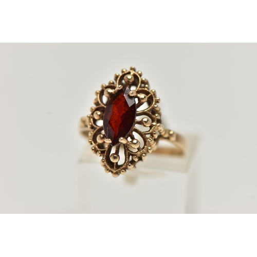 39 - A 9CT GOLD GARNET RING, of an openwork marquise outline, set to the centre with a marquise cut garne... 