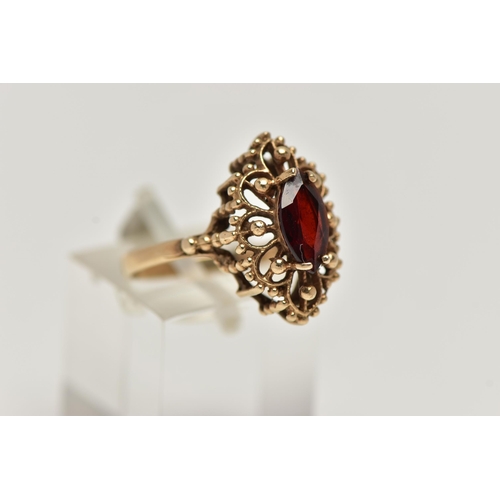 39 - A 9CT GOLD GARNET RING, of an openwork marquise outline, set to the centre with a marquise cut garne... 